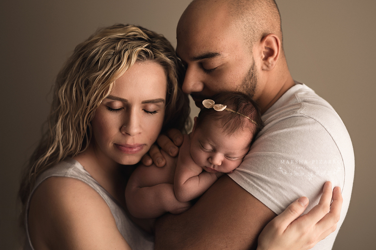 Newborn with parents in white