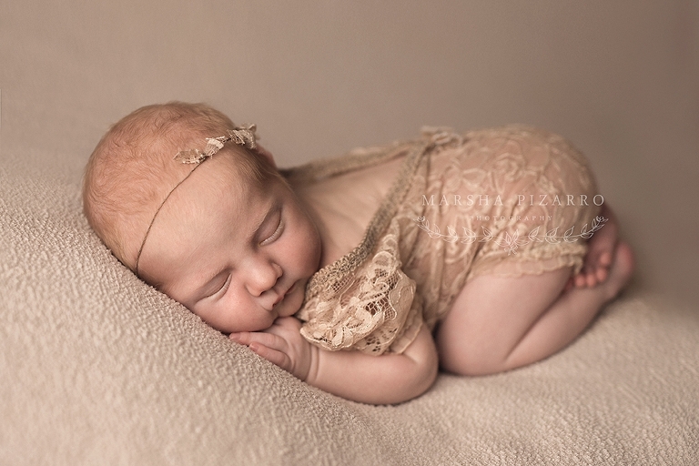 newborn baby in cream romper